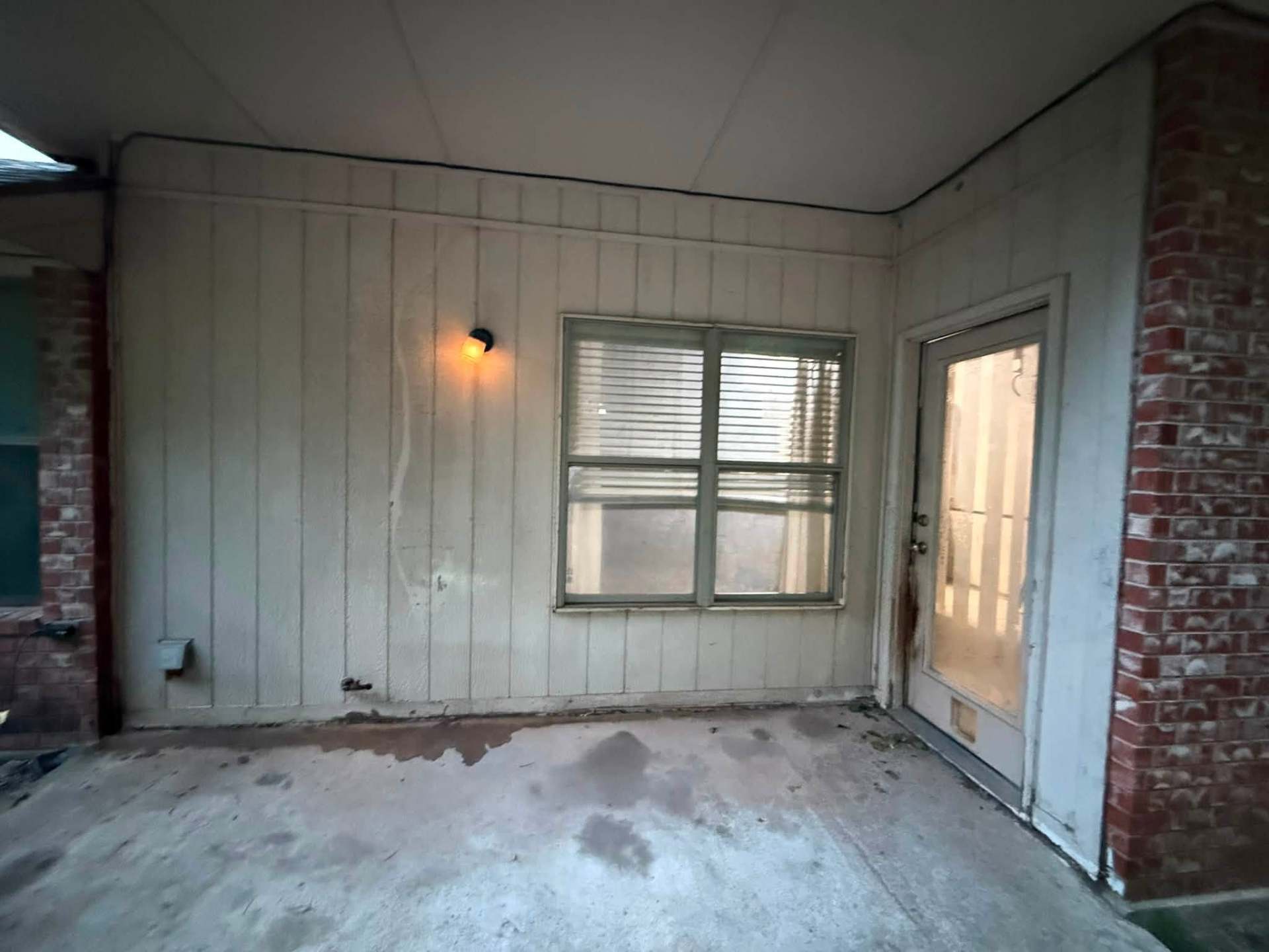 Covered patio before painting, with dingy siding