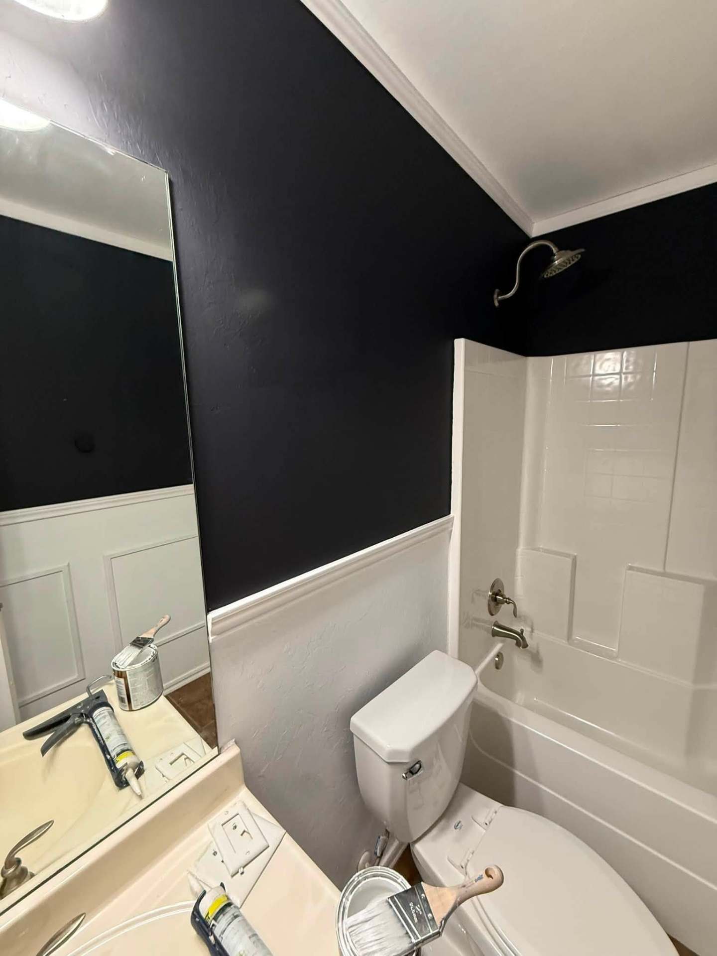 Bathroom repainted in deep navy with white wainscoting